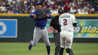 Mookie Betts, de los Dodgers de Los Ángeles, retira a Geraldo Perdomo, de los Diamondbacks de Arizona, con un batazo de Gabriel Moreno en la primera entrada del juego de béisbol de Grandes Ligas del domingo 9 de agosto de 2026, en Phoenix. (AP Foto/Rick Scuteri)