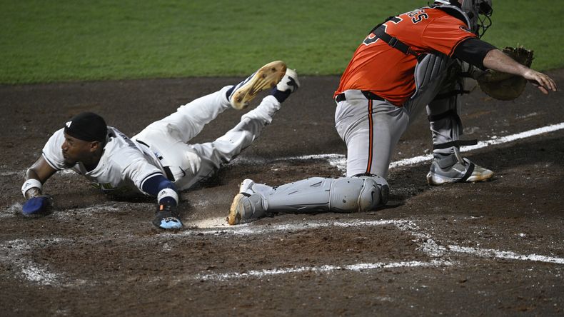 Chandler Simpson, de los Rays de Tampa Bay, se desliza para anotar frente a Jacob Stallings, catcher de los Orioles de Baltimore, el sábado 19 de julio de 2025 (AP Foto/Phelan M. Ebenhack)