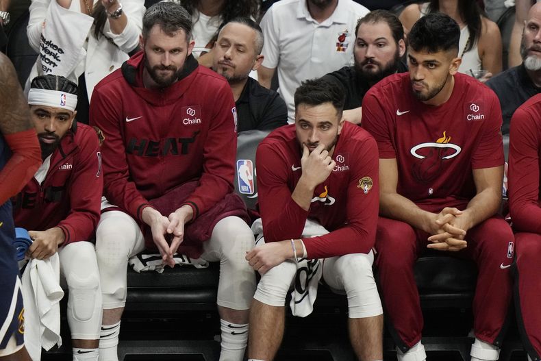 Los jugadores del Heat de Miami, sentados en el banquillo, ven la segunda mitad del cuarto duelo de las Finales ante los Nuggets de Denver, el viernes 9 de junio de 2023 (AP Foto/Lynne Sladky)