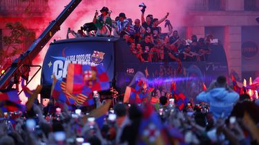 Jugadores del equipo femenino y masculino del Barcelona celebran en un autobús destapado la obtención de los títulos de liga por las calles de la capital catalana el lunes 15 de mayo del 2023.(AP Foto/Joan Monfort)