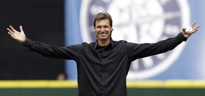ARCHIVO - Randy Johnson, quien fuera lanzador de los Marineros de Seattle, recibe una ovación de los fanáticos mientras se alista para realizar el primer lanzamiento previo a un partido contra los Atléticos de Oakland, el 12 de abril de 2010, en Seattle. (AP Foto/Elaine Thompson, Archivo)