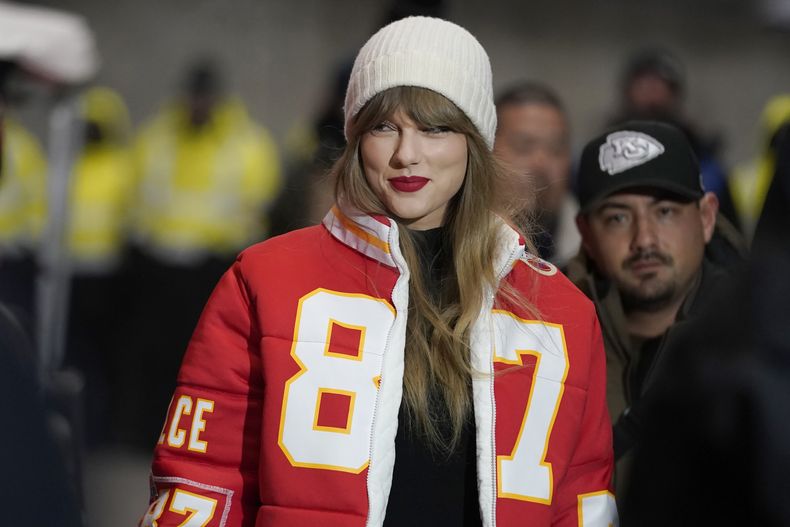 ARCHIVO - Taylor Swift lleva un abrigo con el número del tight end de Kansas CityTravis Kelce diseñada por Kristin Juszczyk, antes de llegar a un partido de postemporada de la NFL entre los Chiefs y los Dolphins de Miami el 13 de enero de 2024, en Kansas City, Missouri. (Foto AP/Ed Zurga, archivo)