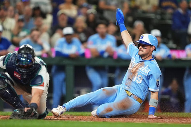 Michael Massey, de los Reales de Kansas City, anota con un elevado de sacrificio productor de Isaac Collins antes del tiro al receptor de los Marineros de Seattle, Mitch Garver, durante la décima entrada de un partido de béisbol, el sábado 2 de mayo de 2026, en Seattle. (Foto AP/Lindsey Wasson)
