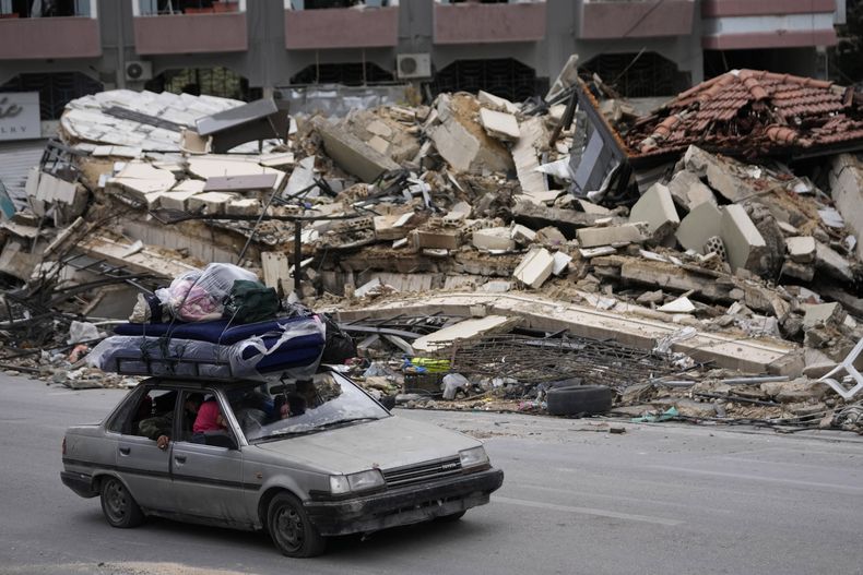 ARCHIVO - Vecinos desplazados pasan junto a los escombros de edificios destruidos a su regreso a sus pueblos tras un cese el fuego entre Israel y Hezbollah que entró en vigencia l día anterior, en Tyre, sur de Líbano, el 27 de noviembre de 2024. (AP Foto/Hussein Malla, Archivo)