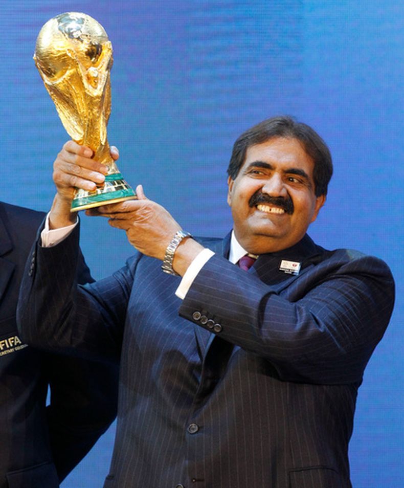 ARCHIVO - El jeque Hamad bin Khalifa Al Thani, emir de Qatar, sostiene el trofeo del Mundial de fútbol tras el anuncio de que Qatar organizaría el torneo de 2022 de la Copa del Mundo en Zúrich, Suiza, el 2 de diciembre de 2010. (AP Foto/Anja Niedringhaus, Archivo)