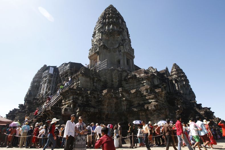 ARCHIVO - Turistas hacen fila para subir al templo de Angkor Wat en las afueras de Siem Reap, Camboya, el 31 de diciembre de 2017. (Foto AP/Heng Sinith, Archivo)