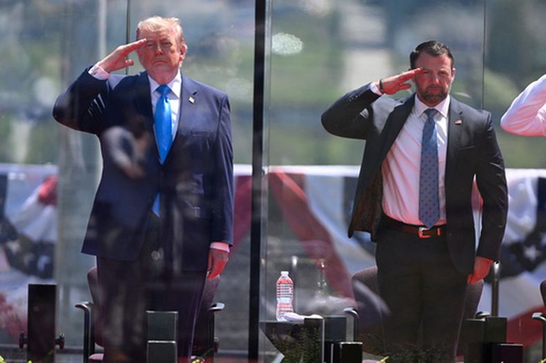 El presidente de Estados Unidos, Donald Trump, izquierda, y el secretario de Seguridad Nacional Markwayne Mullin, derecha, saludan al inicio de la ceremonia de graduación en la Academia de la Guardia Costera de Estados Unidos en New London, Connecticut, el miércoles 20 de mayo de 2026. (AP Foto/Jessica Hill)