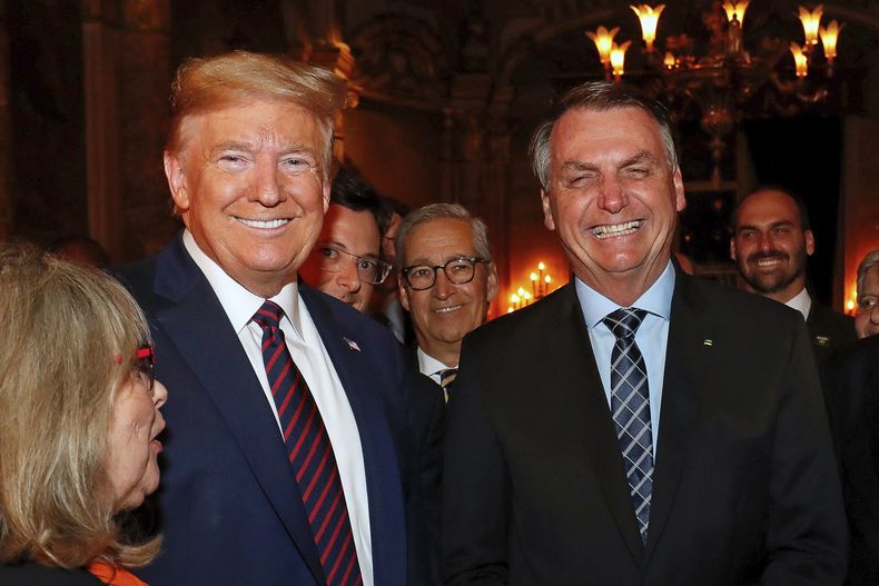 ARCHIVO – El presidente de Brasil, Jair Bolsonaro, derecha, con el presidente Donald Trump, en un almuerzo en Mar-a-Lago, Palm Beach, Florida, el 7 de marzo de 2020. Eduardo, el hijo de Bolsonaro, aparece en el fondo, a la derecha. (Alan Santos/Oficina Presidencial de Prensa de Brasil vía AP, Archivo)