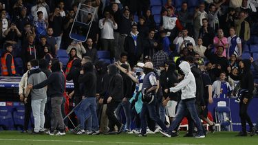 Seguidores del Espanyol saltan a la cancha y lanzan objetos después de que el Barcelona vencieran al Espanyol y confirmara el título de liga el domingo 14 de mayo del 2023. (AP Foto/Joan Monfort)