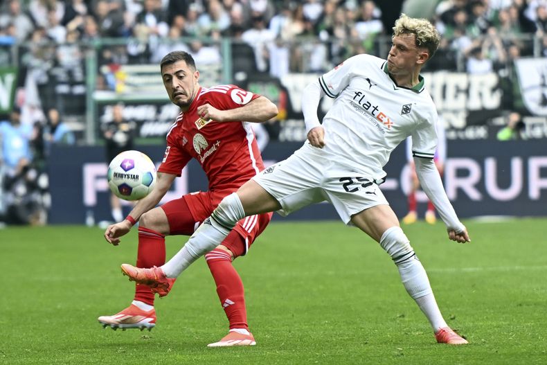 Robin Hack, del Mönchengladbach, derecha, y Josip Juranovic, de Union Berlín, disputan un balón durante el partido de fútbol de la Bundesliga entre Borussia Mönchengladbach y 1. FC Union Berlín, en Mönchengladbach, Alemania, el domingo 28 de abril de 2024. (Federico Gambarini/dpa via AP)