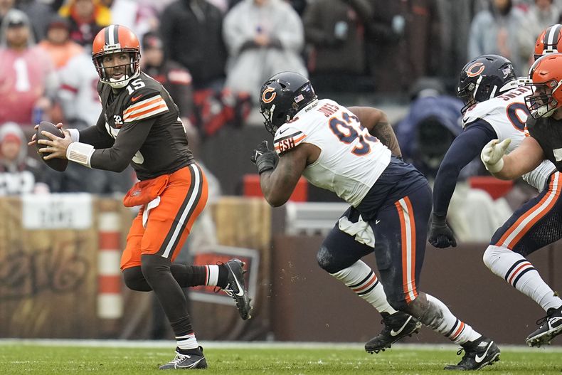 El quarterback Joe Flacco (15), de los Browns de Cleveland, se quita la presión para intentar lanzar un pase, mientras que lo persigue Justin Jones (93), de los Bears de Chicago, en la primera mitad del juego de la NFL, el domingo 17 de diciembre de 2023, en Cleveland. (AP Foto/Sue Ogrocki)
