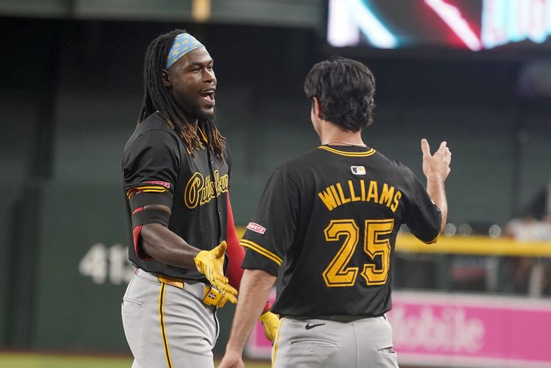 El dominicano de los Piratas de Pittsburgh, Oneil Cruz (izquierda) y Alika Williams (derecha) celebran al llegar a base durante la décima entrada del juego de béisbol ante los Diamondbacks de Arizona, el domingo 28 de julio de 2024, en Phoenix. (AP Foto/Darryl Webb)