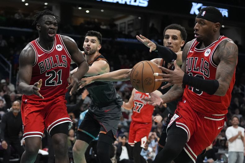 Adama Sanogo (21) pasa el balón a Torrey Craig, su compañero en los Bulls de Chicago, durante el partido del viernes 12 de abril de 2024, ante los Wizards de Washington (AP Foto/Mark Schiefelbein)