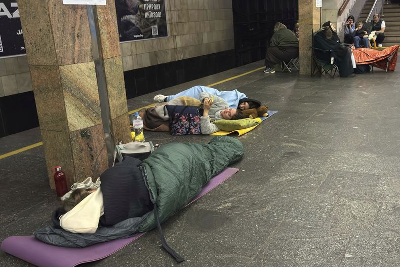 Varias personas descansan en la estación Kontraktova Ploshcha del tren subterráneo durante un ataque ruso con drones y misiles, el sábado 24 de mayo de 2025, en Kiev, Ucrania. (AP Foto/Illia Novikov)
