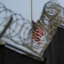 En esta imagen del 29 de agosto de 2021 revisada por oficiales militares de Estados Unidos, una bandera ondea a media asta en una vista desde Camp Justice, en la Base Naval de Bahía de Guantánamo, Cuba. (AP Foto/Alex Brandon, Archivo)