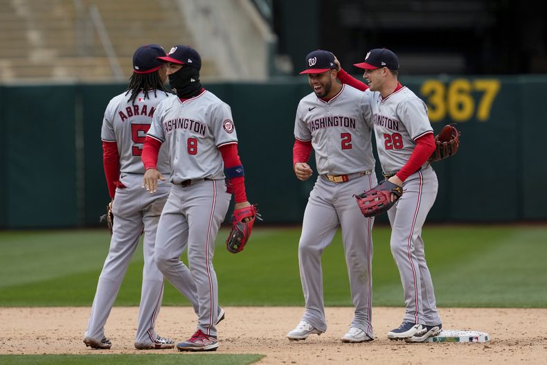 El jardinero derecho de los Nacionales de Washington, Lane Thomas (28), y el segunda base Luis García Jr. (2), celebran después de la victoria del equipo sobre los Atléticos de Oakland después del juego de béisbol el sábado 13 de abril de 2024 en Oakland, California (AP Foto/Godofredo A. Vásquez)
