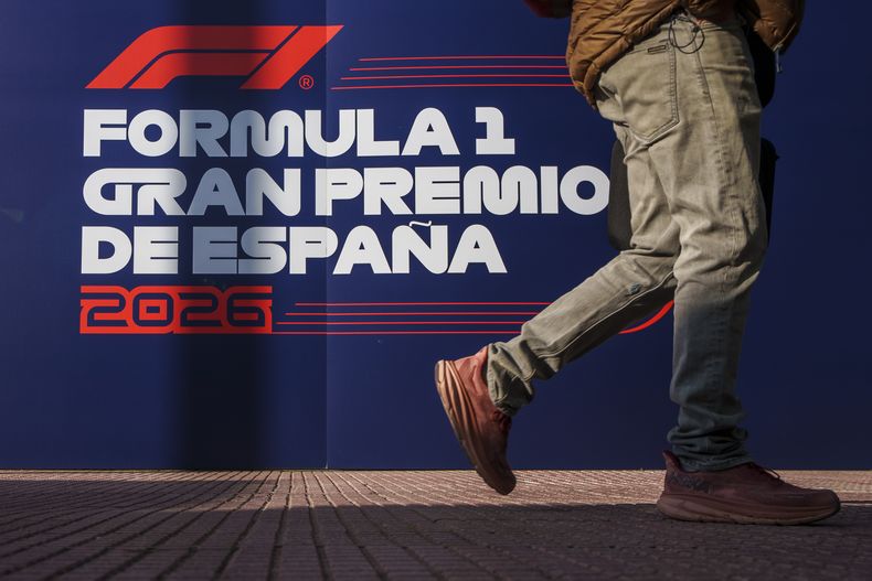 Un individuo camina frente al logo del Gran Premio de España en el palacio de convenciones IFEMA en Madrid, España, el martes 23 de enero de 2024. (AP Foto/Manu Fernández)