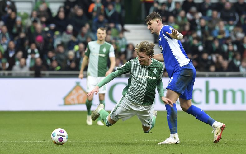 Fabian Nrnberger, de Darmstadt, pelea un balón con Nick Woltemade, izquierda, de Werder Bremen, durante el juego de fútbol de la Bundesliga entre Darmstadt 98 y Werder Bremen en el estadio Weserstadion, en Bremen, Alemania, el sábado 24 de febrero de 2024. (Carmen Jaspersen/dpa vía AP)