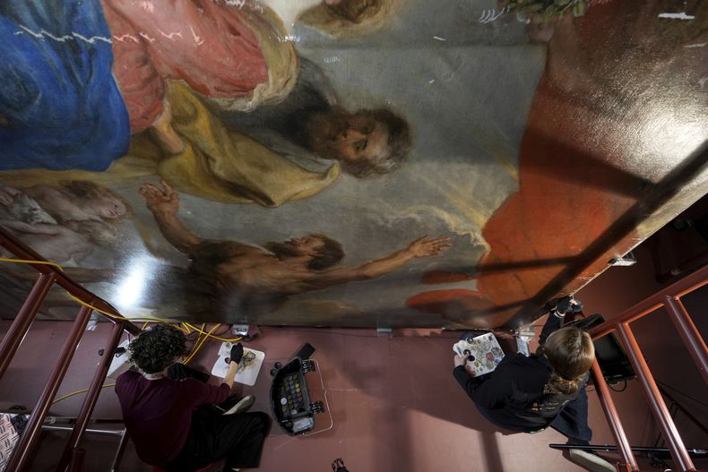 Las restauradoras de arte Jill Keppens, izquierda, y Kayla Metelenis, derecha, trabajan en secciones de Madonna entronizada con niño, rodeada de santos, pintada por el artista flamenco Peter Paul Rubens, en el Museo Real de Bellas Artes de Amberes, Bélgica, el martes 28 de enero. 2025. (Foto AP/Virginia Mayo)