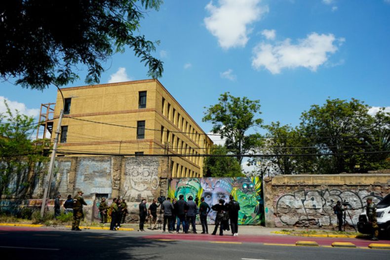 ARCHIVO - Periodistas frente al internado escolar nacional Barros Arana tras un incendio en Santiago de Chile, el 23 de octubre de 2024. (Foto AP/Esteban Félix, archivo)
