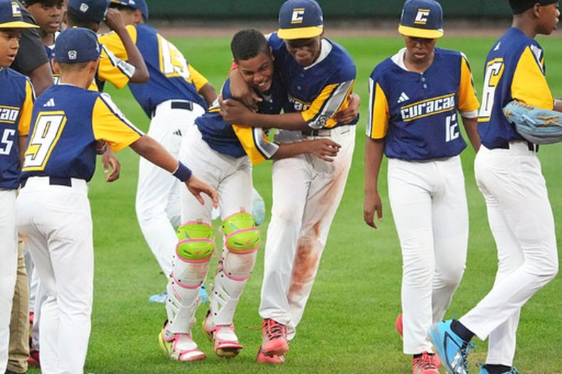 Ignacio Lindo del V-dien de Curaçaos junto al cátcher Naeem Angel Coeriel celebran con el resto del equipo tras ganar la Serie Mundial de las Ligas Pequeñas al vencer a Nevada el domingo 30 de agosto del 2026. (AP Foto/Gene J. Puskar)