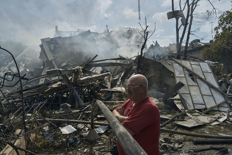 Un hombre observa las tareas de las cuadrillas de emergencia en el lugar donde un edificio fue destruido durante un ataque ruso en Odesa, Ucrania, el jueves 20 de julio de 2023. (AP Foto/Libkos)