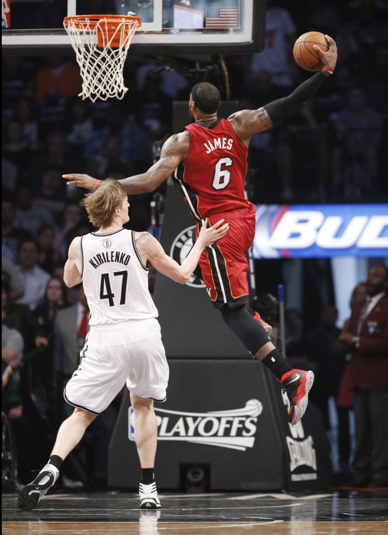 LeBron James, del Heat de Miami, encesta frente al ruso Andrei Kirilenko, de los Nets de Brooklyn, en el cuarto partido de la semifinal de la Conferencia del Este, el lunes 12 de mayo de 2014 (AP Foto)