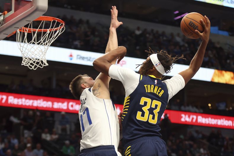 Luka Doncic (77), de los Mavericks de Dallas, intenta bloquear un tiro de Myles Turner (33), de los Pacers de Indiana, durante la primera mitad del juego de baloncesto de la NBA, el lunes 4 de noviembre de 2024, en Dallas. (AP Foto/Richard W. Rodriguez)