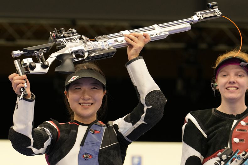 La surcoreana Ban Hyojin (izquierda) celebra tras ganar la final de la carabina de aire de 10 metros en los Juegos Olímpicos de París, con la suiza Audrey Gogniat (tercera), el lunes 29 de julio de 2024, en Chateauroux, Francia. (AP Foto/Manish Swarup)