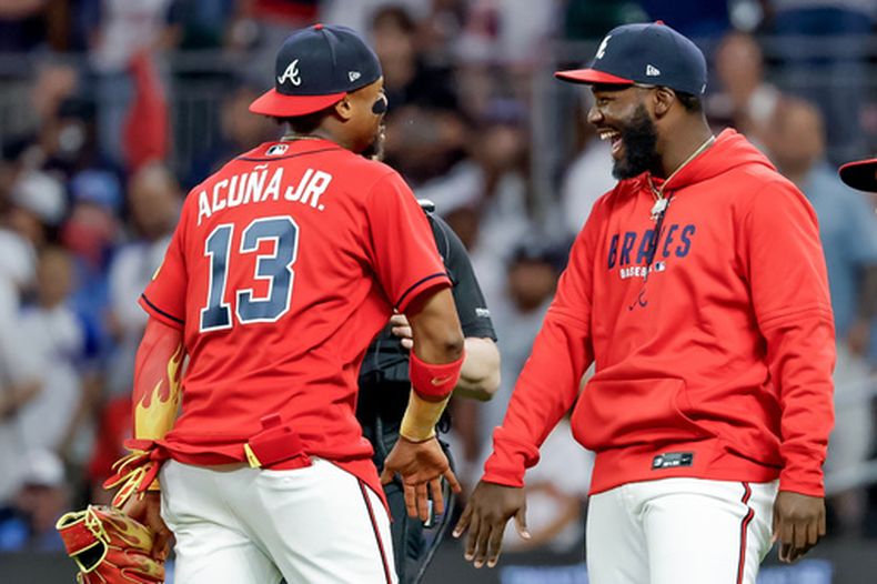 Ronald Acuna Jr. (13) y Michael Harris II, derecha, de los Bravos de Atlanta, celebran después de la victoria sobre los Filis de Filadelfia en el juego de béisbol de Grandes Ligas del viernes 24 de abril de 2026, en Atlanta. (AP Foto/Erik S. Lesser)