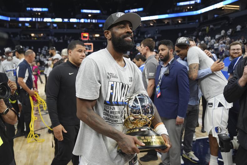Kyrie Irving, base de los Mavericks de Dallas, con el trofeo de campeones de la Conferencia Oeste ante los Timberwolves de Minnesota, el jueves 30 de mayo de 2024. (AP Foto/Abbie Parr)