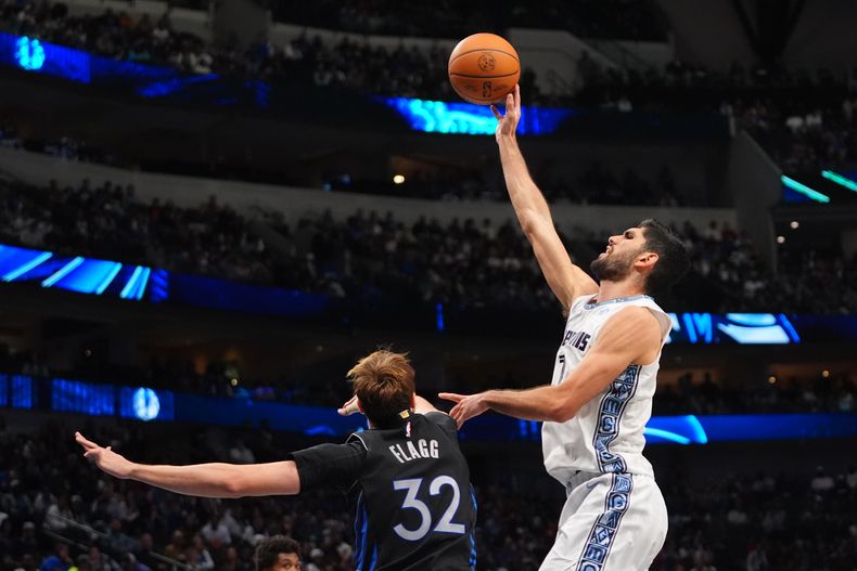 El español Santi Aldama, de los Grizzlies de Memphis, dispara frente a Cooper Flagg, de los Mavericks de Dallas, en el duelo del sábado 22 de noviembre de 2025 (AP Foto/LM Otero)