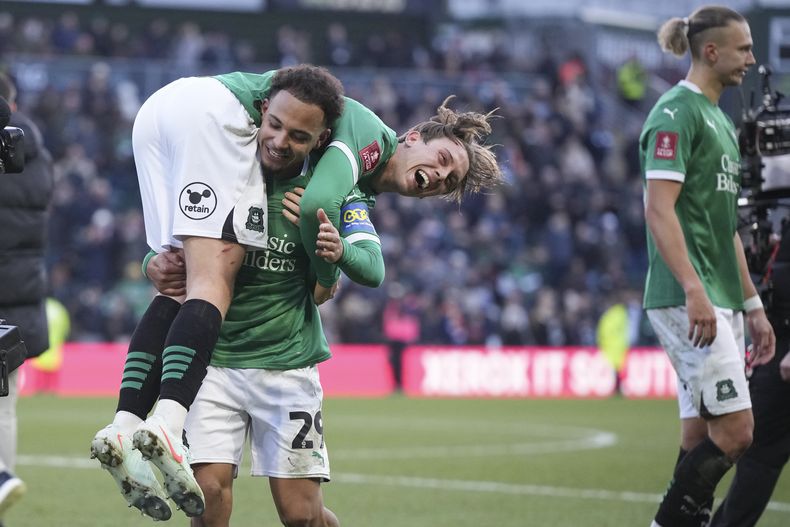 Callum Wright de Plymouth es alzado por su compañero Matthew Sorinola al celebrar la victoria 1-0 ante Liverpool en el partido de la cuarta ronda de la Copa FA, el domingo 9 de febrero de 2025. (AP Foto/Alastair Grant)