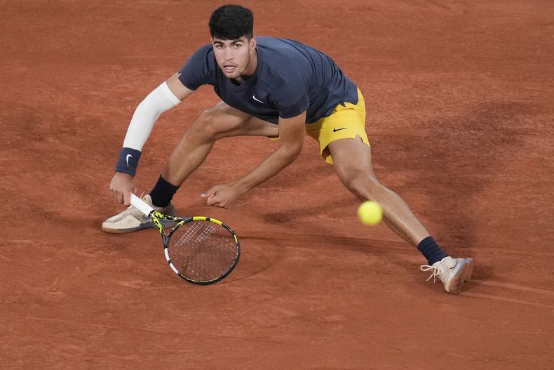 Carlos Alcaraz se desliza durante el partido contra Jeffrey John Wolf en la primera ronda del Abierto de Francia, el domingo 26 de mayo de 2024. (AP Foto/Christophe Ena)