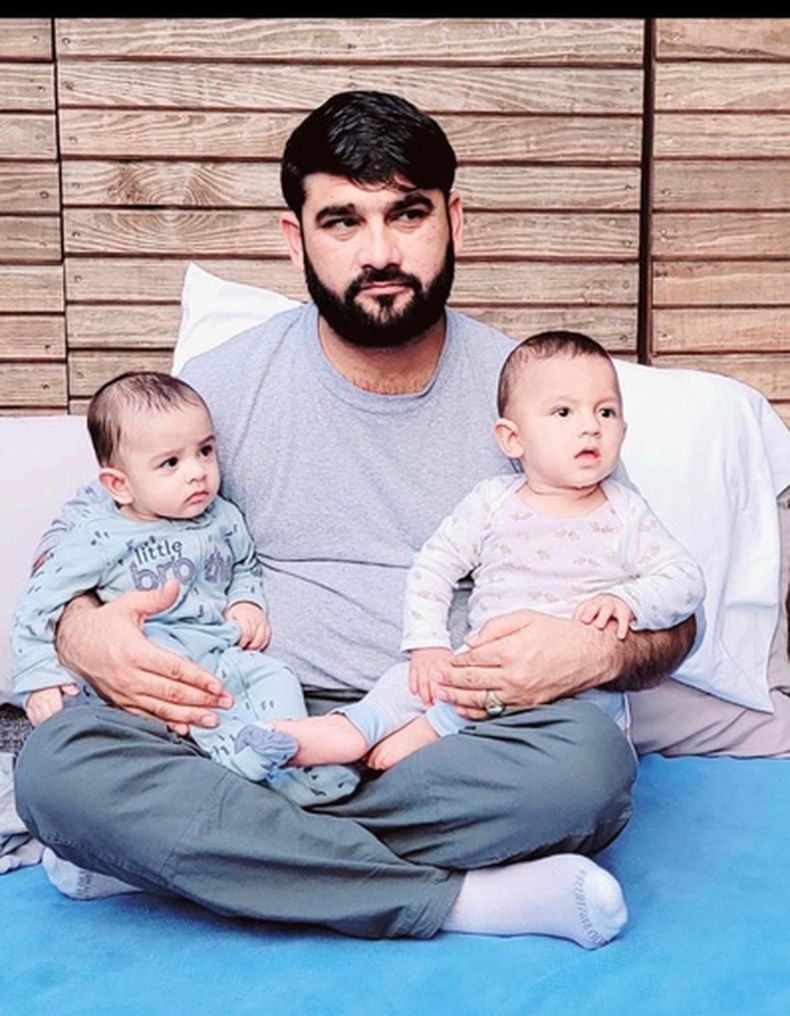 Mohammad Nazeer Paktiawal, un ciudadano afgano que murió estando detenido por ICE el 14 de marzo del 2026, en una foto sin fecha, con dos de sus seis hijos. (Familia Paktiawal via AfghanEvac via AP)