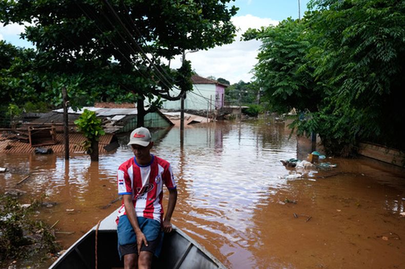 Javier Barreto navega en una embarcación por una calle inundada por el río Paraná, tras las fuertes lluvias que provocaron su desbordamiento en Ciudad del Este, Paraguay, el viernes 16 de octubre de 2026. (Foto AP/Jorge Saenz)