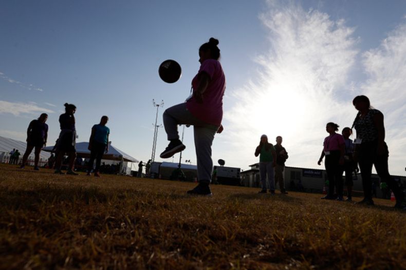 ARCHIVO - Inmigrantes juegan al fútbol en un centro de acogida del gobierno estadounidense para niños migrantes, en Carrizo Springs, Texas, el 9 de julio de 2019. (AP Foto/Eric Gay/Archivo)