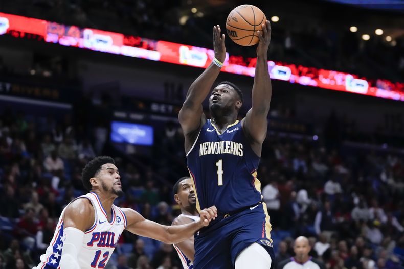 El alero de los Pelicans de Nueva Orleans Zion Williamson salta hacia la canasta para lanzar el balón frente al alero de los 76ers de Filadelfia Tobias Harris en el encuentro del miércoles 29 de noviembre del 2023. (AP Foto/Gerald Herbert)