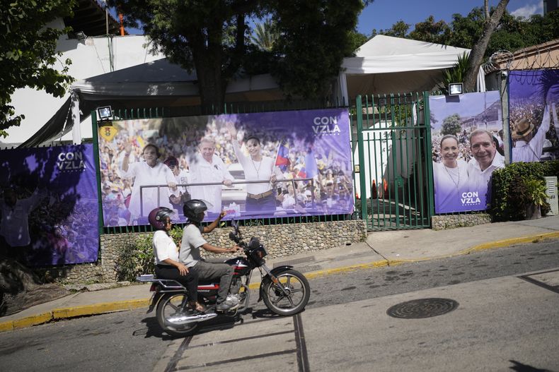 Una motocicleta pasa frente a la sede de la campaña electoral de la líder opositora María Corina Machado y del candidato presidencial Edmundo González en Caracas, Venezuela, el viernes 2 de agosto de 2024, luego de que fue saqueada durante la noche. (AP Foto/Matías Delacroix)