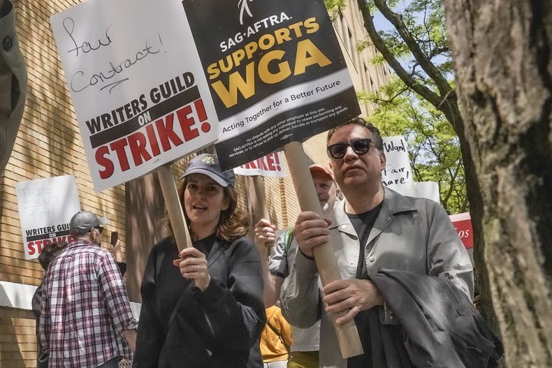 ARCHIVO - Los actores y comediantes Tina Fey, al centro, y Fred Armisen, a la derecha, se unen a miembros en huelga del Sindicato de Guionistas de Estados Unidos durante un mitin frente a Silvercup Studios, el martes 9 de mayo de 2023, en Nueva York. Los actores sindicalizados de Hollywood al borde de una huelga acordaron permitir una intervención de última hora de los mediadores federales, pero dicen que dudan que se llegue a un acuerdo antes de la fecha límite de negociación del miércoles 12 de julio de 2023. (Foto AP/Bebeto Matthews, archivo)
