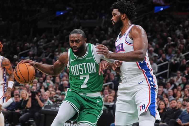 ARCHIVO - Jaylen Brown (7), de los Celtics de Boston, lleva el balón hacia la canasta frente a Joel Embiid, derecha, de los 76ers de Filadelfia, durante la primera mitad de un juego de baloncesto de la NBA, el miércoles 22 de octubre de 2025, en Boston. (AP Foto/Charles Krupa, Archivo)