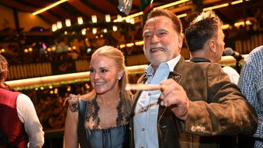 Arnold Schwarzenegger y su pareja, Heather Milligan, en el escenario durante la 190ma edición del Oktoberfest, el viernes 26 de septiembre de 2025, en Múnich, Alemania. (Felix Hörhager/dpa vía AP)
