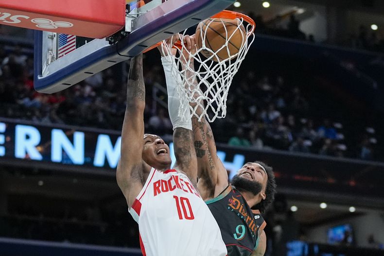 El alero de los Rockets de Houston Jabari Smith Jr. clava el balón frente al alero de los Wizards de Washington Justin Champagnie en el encuentro de la NBA del martes 19 de marzo del 2024. (AP Foto/Alex Brandon)