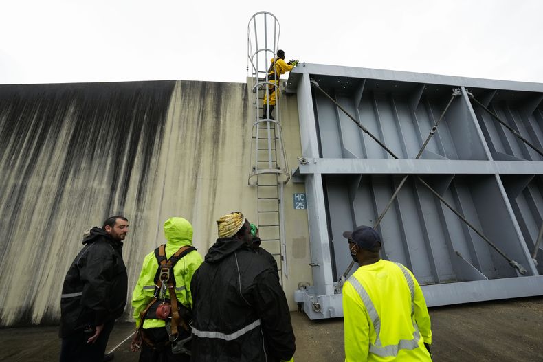 Trabajadores de la Autoridad de Protección contra Inundaciones del Sureste de Luisiana cierran puertas de contención en el canal Harvey, justo al límite de la ciudad de Nueva Orleans, antes de la tormenta tropical Francine, en Harvey, Luisiana, el martes 10 de septiembre de 2024. (AP Foto/Gerald Herbert)