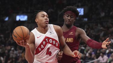Scottie Barnes, de los Raptors de Toronto, se enfila a una canasta ante la presión defensiva de Caris LeVert, de los Cavaliers de Cleveland, durante la primera mitad del juego de baloncesto de la NBA, en Toronto, el lunes 1 de enero de 2024. (Chris Young/The Canadian Press vía AP)