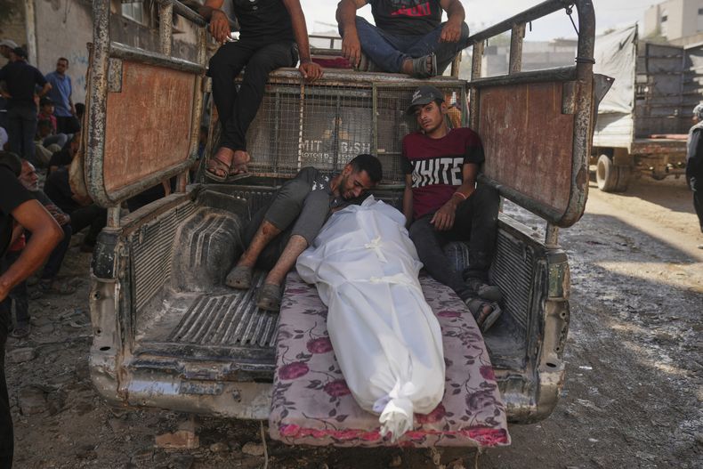 Palestinos lloran junto al cuerpo de un hombre asesinado cuando intentaba llegar a un camión con ayuda humanitaria que entraba al norte de Gaza a través del cruce de Zikim con Israel, en el hospital de Shifa, en la Ciudad de Gaza, el 31 de julio de 2025. (AP Foto/Jehad Alshrafi)