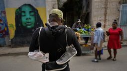 Un vendedor callejero de zapatos busca clientes el miércoles 31 de enero de 2024, en La Habana Vieja, Cuba. (AP Foto/Ramón Espinosa)