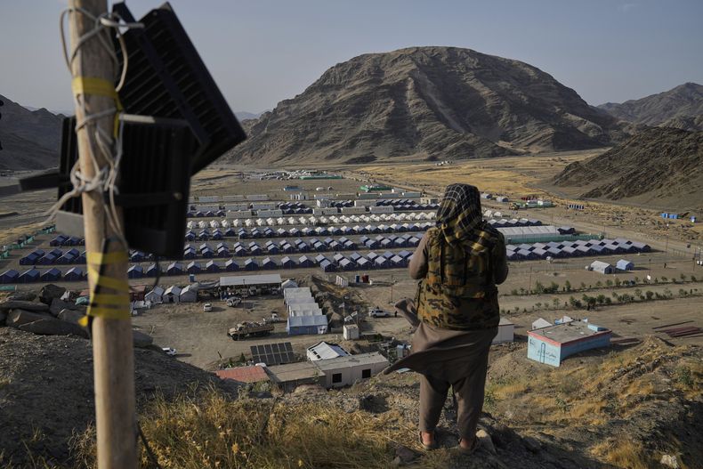 ARCHIVO - Un combatiente talibán observa desde una colina un campamento para albergar a refugiados afganos repatriados desde Pakistán, cerca de la frontera entre Pakistán y Afganistán, en Torkham, Afganistán, el 31 de mayo de 2025. (AP Foto/Ebrahim Noroozi, archivo)