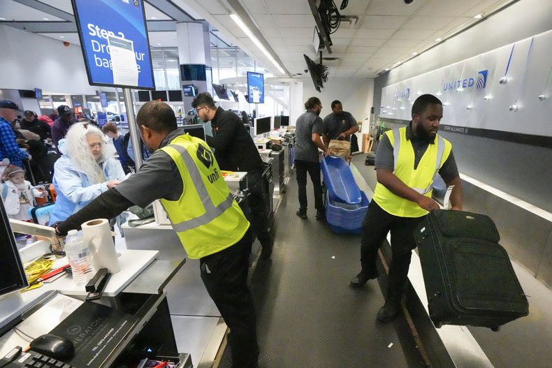 ARCHIVO - Agentes registran a pasajeros y su equipaje en el Aeropuerto Intercontinental George Bush el 21 de diciembre de 2023, en Houston. (Brett Coomer/Houston Chronicle vía AP, archivo)