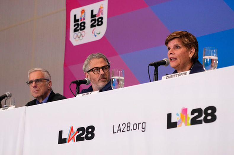 Nicole Hoevertsz, a la derecha, presidenta de la Comisión de Coordinación del COI para LA28, habla mientras Reynold Hoover, a la izquierda, director ejecutivo de LA28, y Casey Wasserman, presidenta de LA28, escuchan durante una conferencia de prensa tras una visita de tres días el jueves 4 de junio de 2026 en Los Ángeles. (Foto AP/Mark J. Terrill)